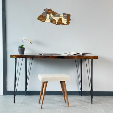Small El Salvador wooden map above a dark console table with iron legs and a cream stool, wide view