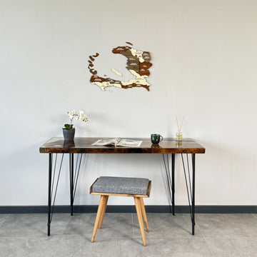 Small Haiti wooden wall map above a desk with a stool