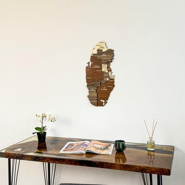Qatar wooden wall map above the left side of a desk with a green mug, tight crop