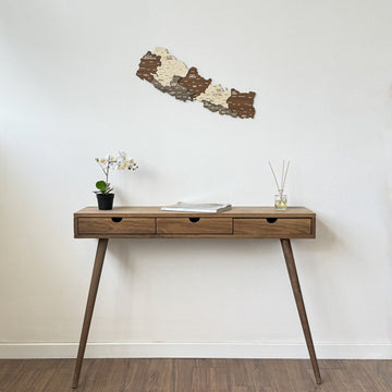Small Nepal wooden wall map above a slim console with splayed legs on a wood floor, wide view