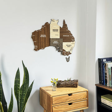 Wooden Australia map with Western Australia, Queensland and Victoria labeled, above a drawer table