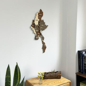 Myanmar wooden wall map in a medium close view above a chest of drawers with flowers in a glass