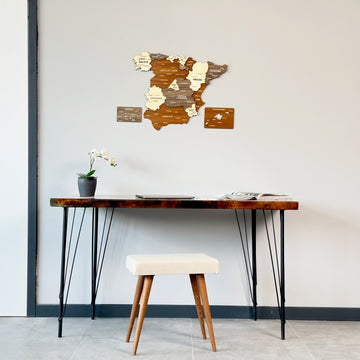 Mixed color Spain wooden wall map with island panels above a hairpin-leg desk and cream stool, wide room view