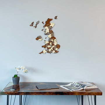United Kingdom wooden wall map close above the end of a resin desk with a magazine
