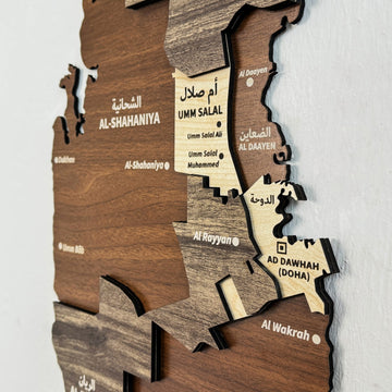 Close-up of Qatar wooden map layers showing Umm Salal, Al-Shahaniya and Ad Dawhah (Doha) in Arabic and English