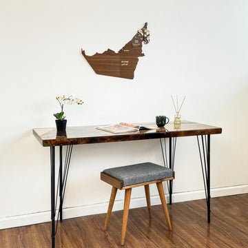 United Arab Emirates wooden wall map above a hairpin-leg desk and a gray stool, medium view