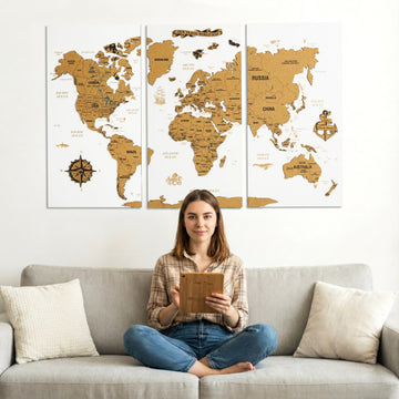 White cork push pin world map in three panels above a gray sofa, with a woman holding a cork board