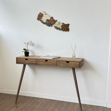 Nepal wooden wall map high on a white wall above a console with a magazine