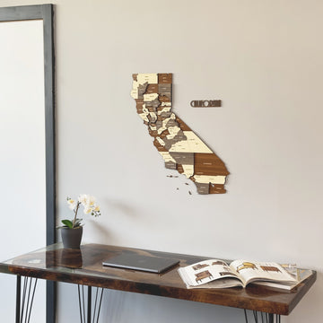 California wooden wall map with its cut-out name, close view above a resin-topped desk
