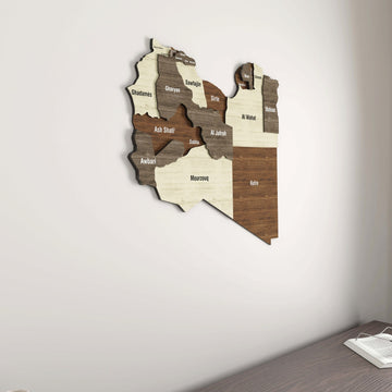 Libya wooden wall map seen from the side angle on a plain white wall, with a desk edge below