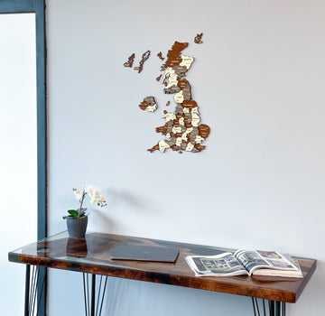United Kingdom wooden wall map above a resin desk with an orchid