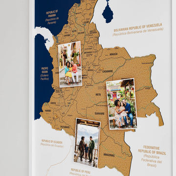 Close-up of the white framed Colombia cork map with three pinned photos and department labels
