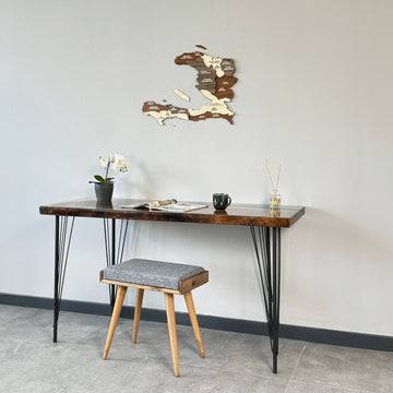 Haiti wooden wall map above a hairpin-leg desk with a gray upholstered stool, wide view