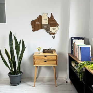 Wooden Australia wall map above a light wood side table in a corner, mid-distance view