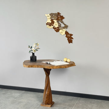 Small Armenia wooden map on a gray wall above a wooden console with flowers, seen from a slight right angle