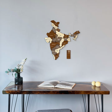 Wooden India map with Andaman piece, angled low view above a desk with a vase