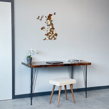 United Kingdom wooden wall map above a desk with a cream stool, medium view