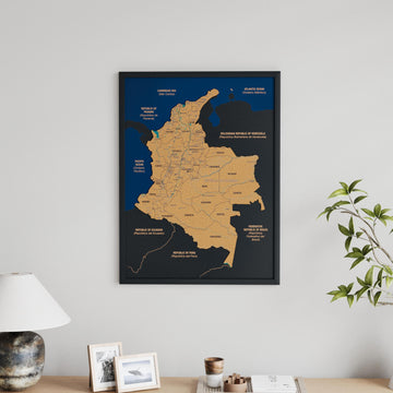 Black framed Colombia cork map on a gray wall above a sideboard with a lamp and framed photos, no pins