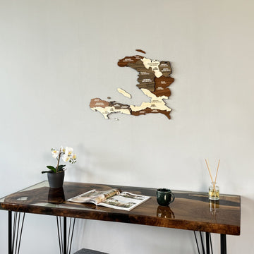Haiti wooden wall map above the corner of a resin desk with an orchid