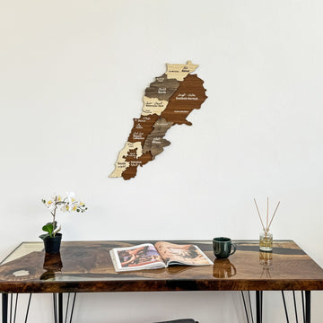 Lebanon wooden wall map on a white wall above a wooden desk with an orchid, wide view