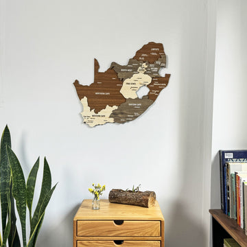 South Africa wooden wall map in a corner room, closer view with a log centerpiece on a drawer table