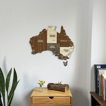 Close view of the wooden Australia wall map above a small drawer table