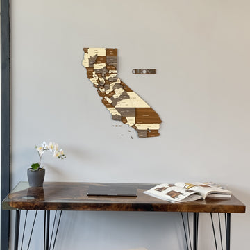 California wooden wall map with name lettering, mid view on a gray wall above a desk