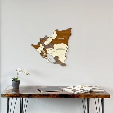 Wooden Nicaragua map above a desk with a magazine, tight crop of the desk top