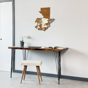 Wide shot of the wooden Guatemala map with Petén in brown above a dark desk