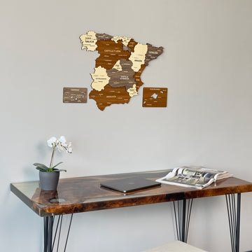Mixed color Spain wooden wall map above the end of a resin desk with an orchid