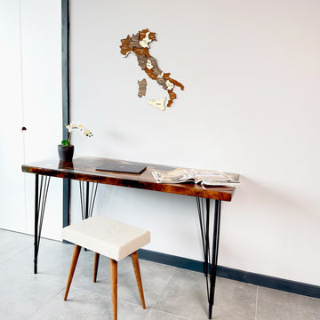 Wooden Italy map with Sardinia and Sicily pieces, angled low view above a desk and white stool