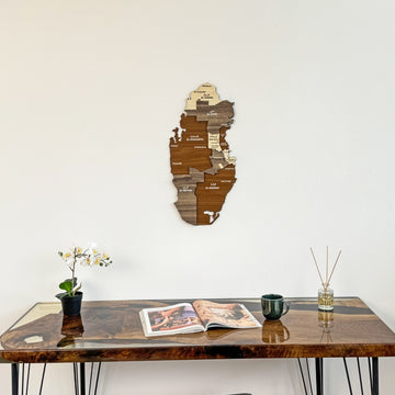 Qatar wooden wall map above a resin-edged wood desk with an orchid, wide view