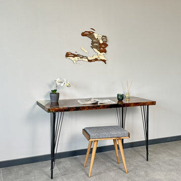Haiti wooden wall map above a resin desk with a green mug