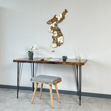 Korea wooden wall map above a hairpin-leg desk with a stool pulled in