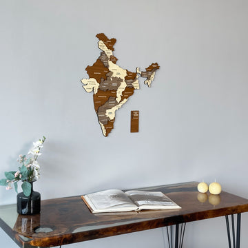 Wooden India wall map above the corner of a walnut desk with two candles