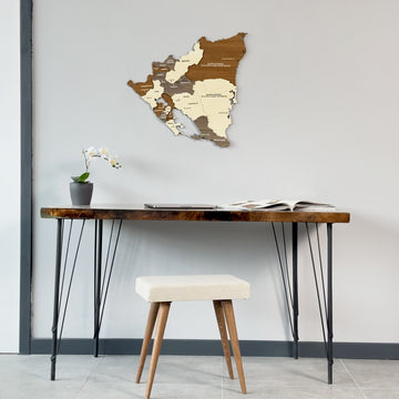 Wooden Nicaragua map above a hairpin-leg desk with a cream stool, wide view