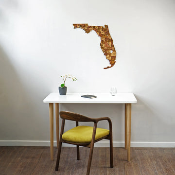 Wooden Florida wall map above a white desk, wide view with a yellow-cushioned chair