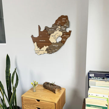 South Africa wooden wall map near stacked books, tight view of the upper map and the drawer table