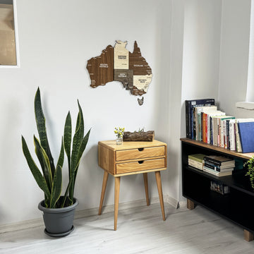 Wooden Australia wall map in a bright corner above a wooden side table