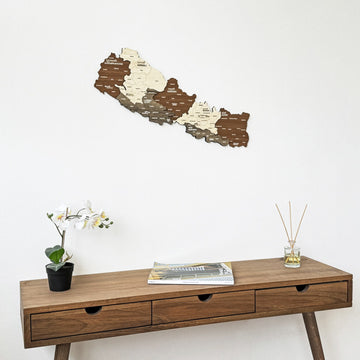 Nepal wooden wall map seen from the left above a walnut console with three drawers