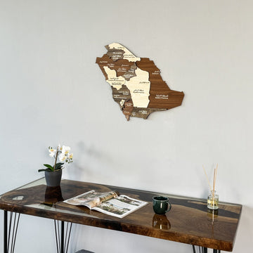 Saudi Arabia wooden wall map seen from a lower angle above a desk with a green cup