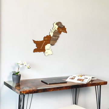 Pakistan wooden wall map close above a resin desk with a laptop