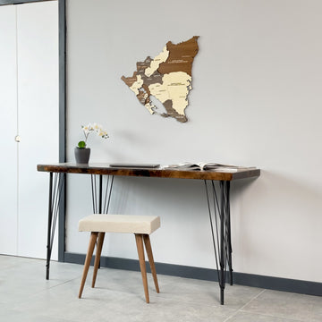 Nicaragua plywood wall map centered above a narrow desk and stool, straight-on view