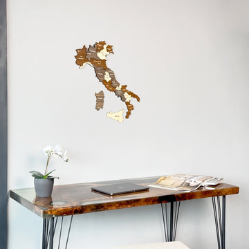 Wooden Italy wall map in mixed wood tones centered above a walnut resin desk