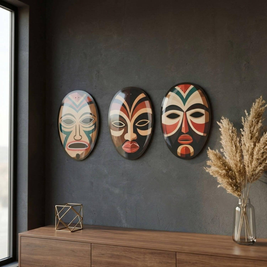 African masks metal wall art set on a dark wall above a wooden cabinet by a window