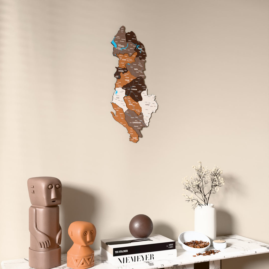 Soil Albania wooden wall map on a beige wall above a console with figurines