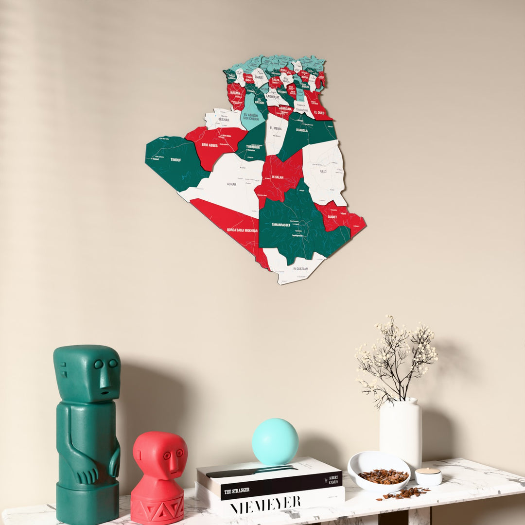 Flag colored Algeria wooden wall map on a beige wall above a console with figurines