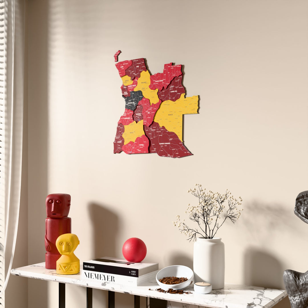 Flag colored Angola wooden wall map beside a sheer curtain, angled view