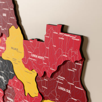 Close-up of the Flag colored Angola wooden wall map with layered regions and printed names