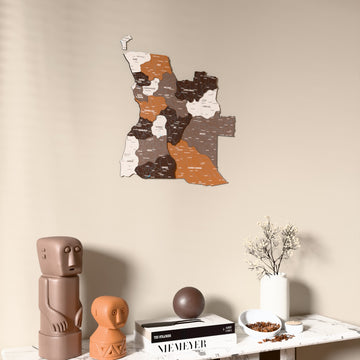 Soil Angola wooden wall map on a beige wall above a console with figurines